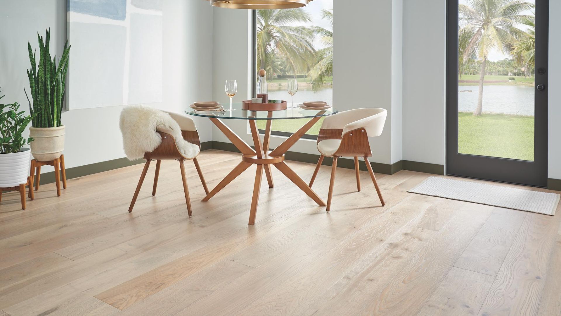 hardwood flooring in a bright dining room with round glass table